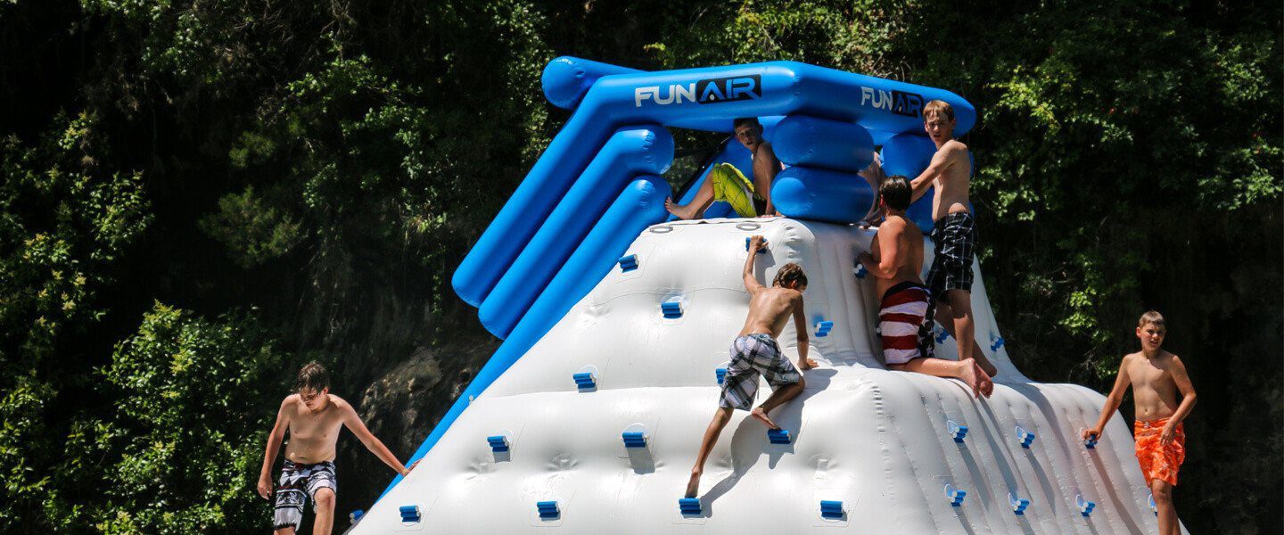 Children on a floating climbing wall with a slide