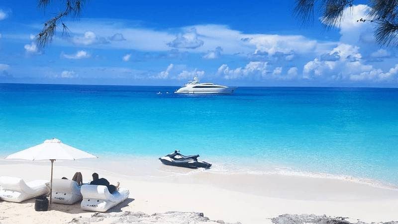 Beach Loungers with jetski on the beach and view of a superyacht