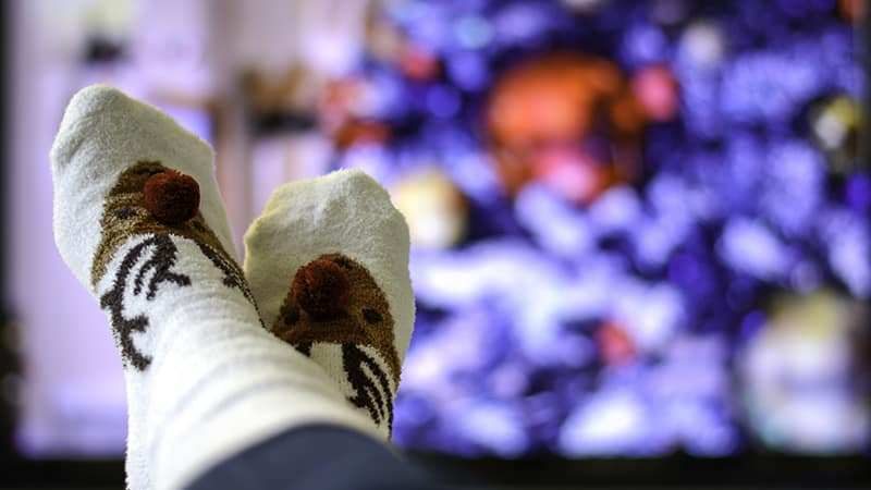 Feet up in Christmas socks watching a movie