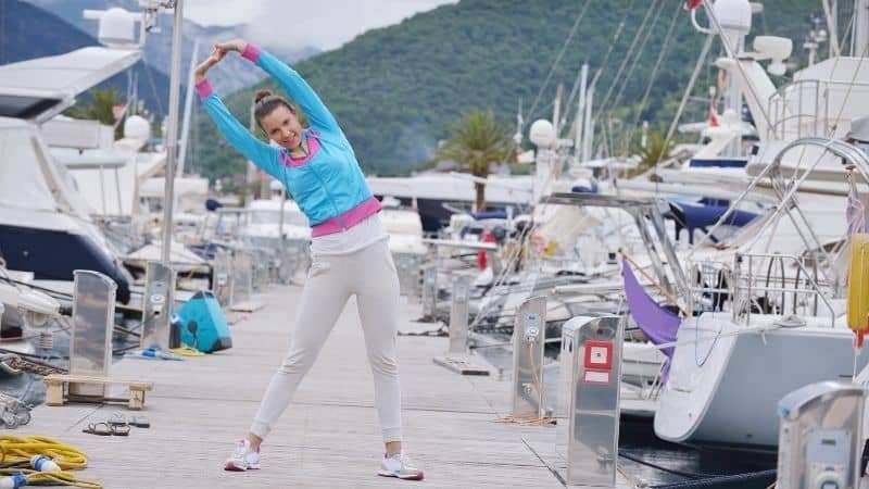 Woman stretching in yacht and sailboat marina