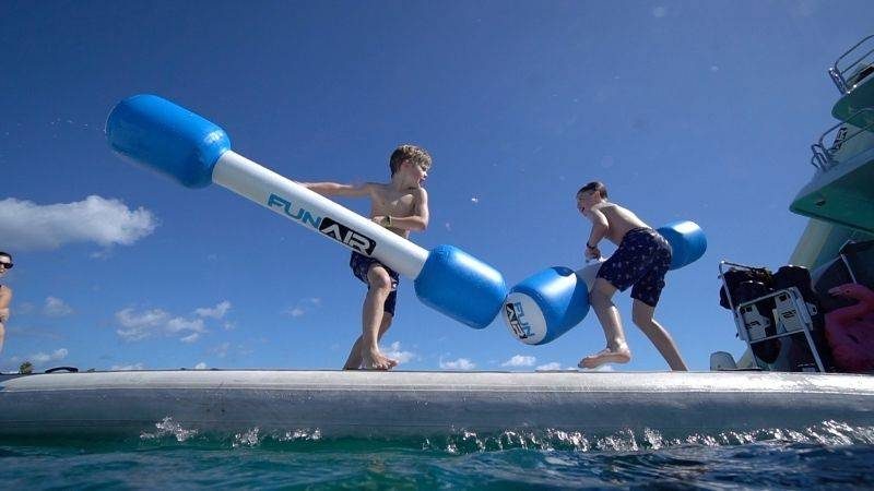 Two boys play fighting on FunAir Water Joust