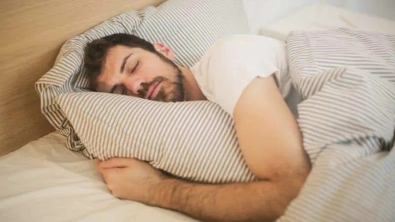 Man sleeping holding on to his pilow