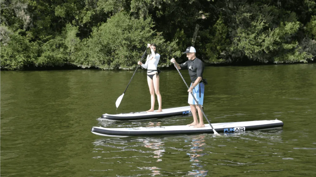 Man and woman on FunAir Stand Up Paddleboard and rowing on a river SUP